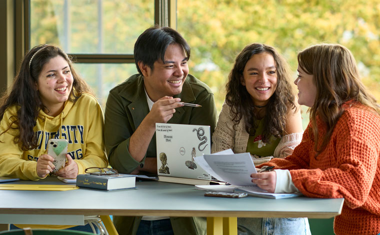 Students standing around a table and lauging