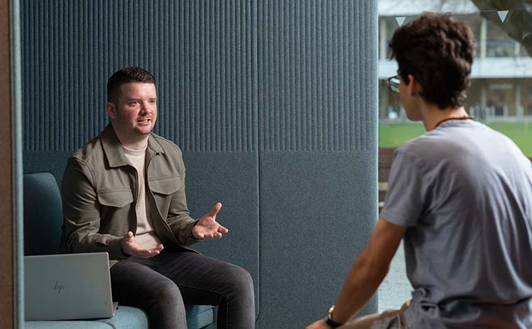 Two students talking in the new student services hub