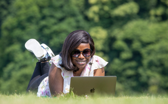 Student with laptop in King's Park in Stirling