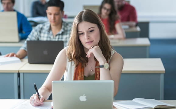 student in library with laptop