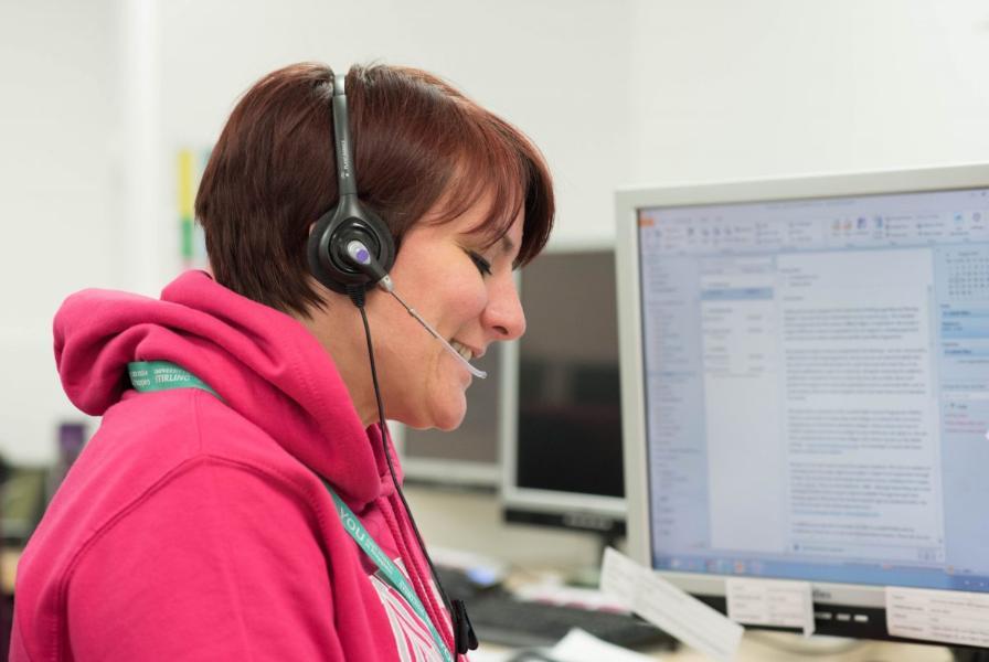 Gemma Connell of the University of Stirling working during UCAS Clearing. She is wearing a headset and operating a computer, whilst answering Clearing calls.