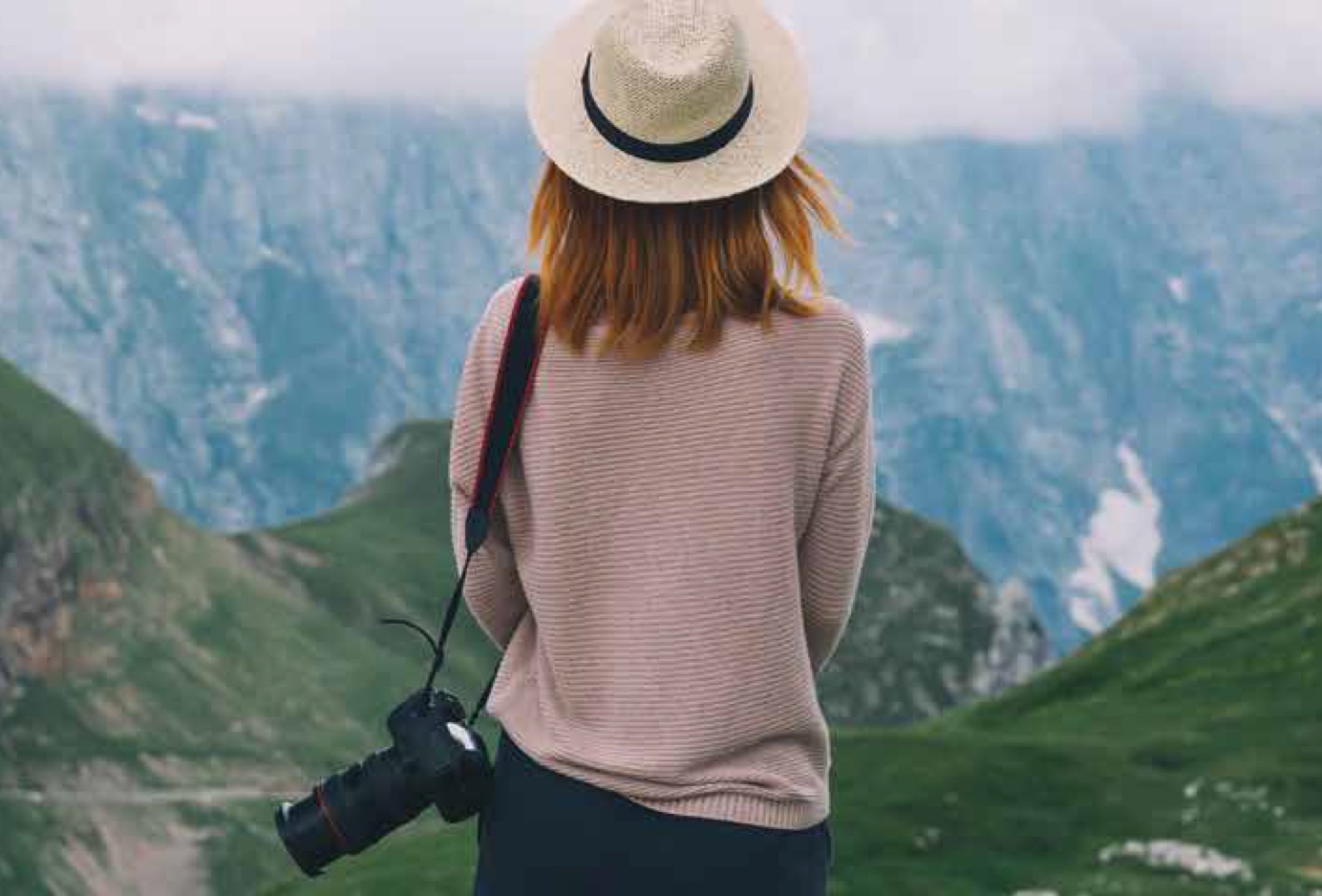 Woman standing on a hilltop looking at mountains