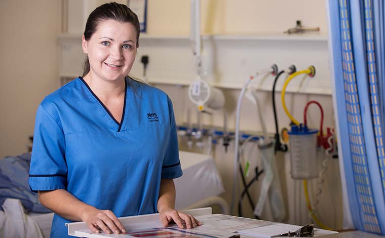 A smiling nurse consulting some notes