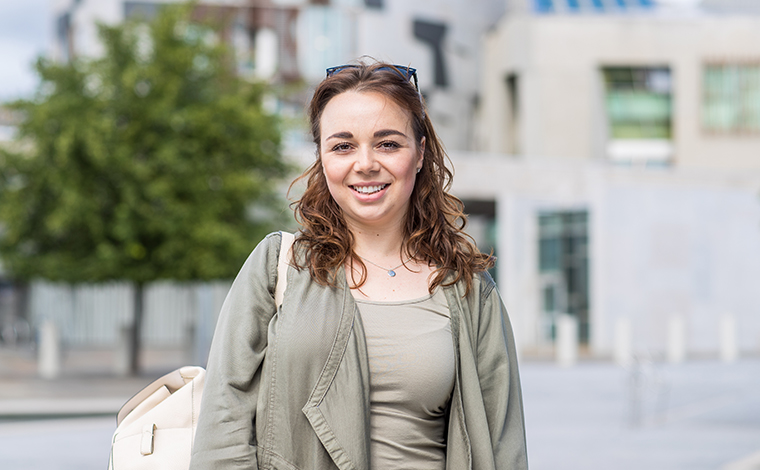 Student in front of the Scottish Parliament