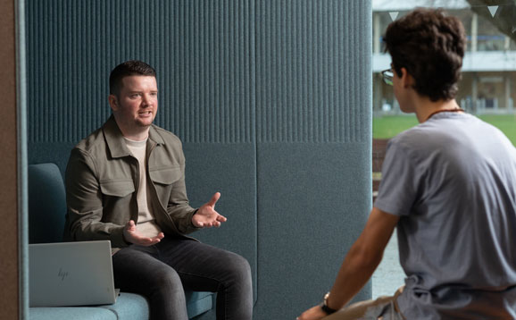 An advisor and a student deep in conversation in the Student Support Hub