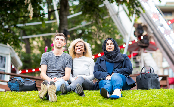 Students sitting in front of a ferris wheel