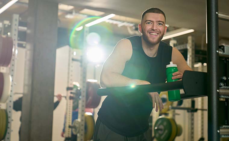 A smiling student drinking water in our strength and conditioning suite