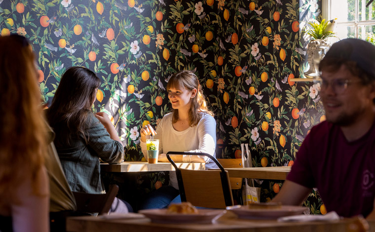 Two friends talking over coffee in a cosy cafe