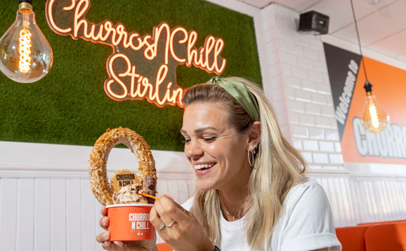 A student enjoying a tub of ice cream and churros