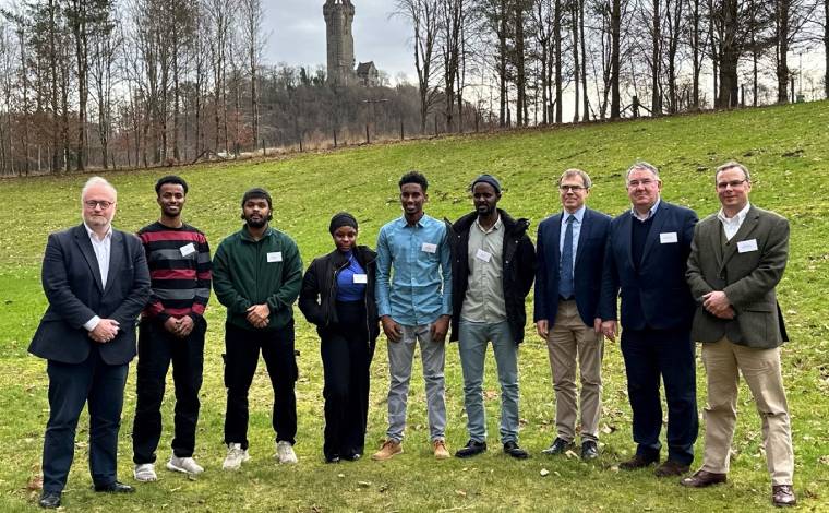 Russell Napier stood on the University grounds with five Karen Napier scholars