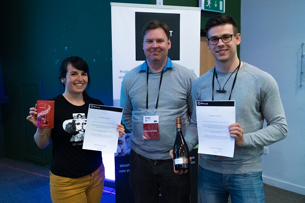 one woman and two men posing with a box of chocolates and certificates 