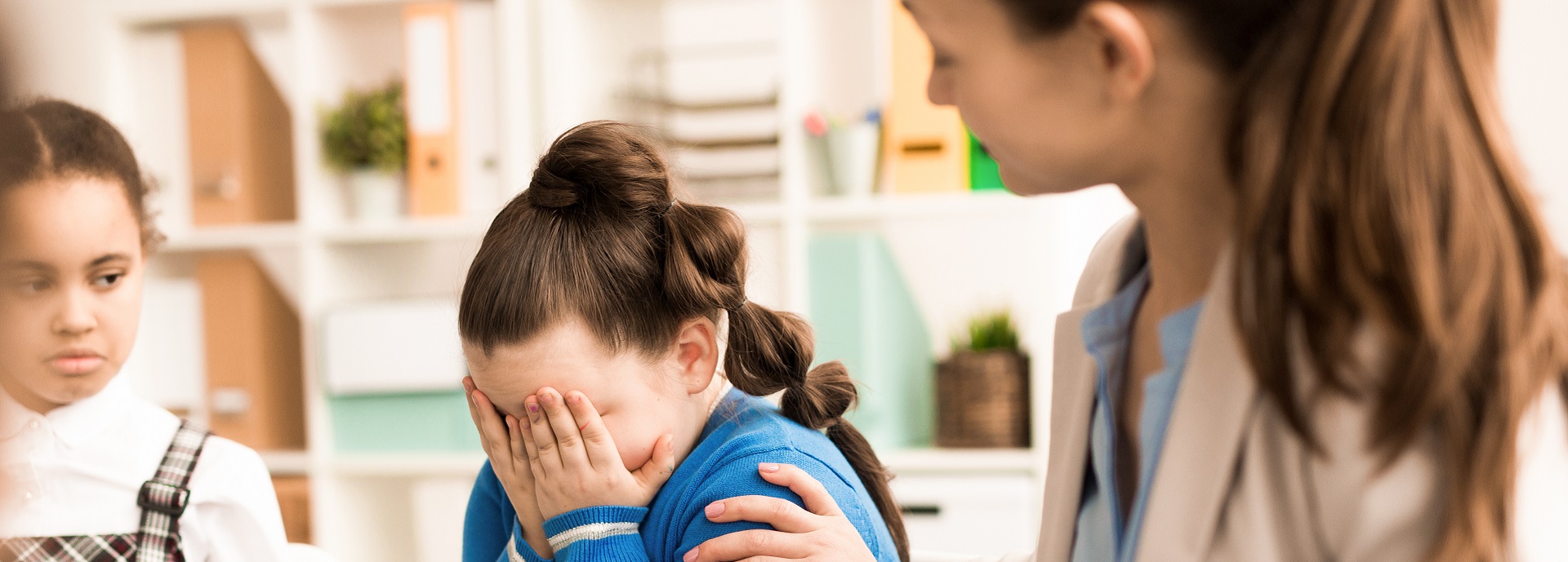 Crying girl being comforted by woman