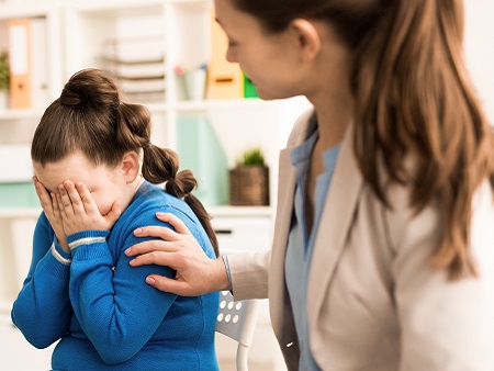 Crying girl being comforted by woman