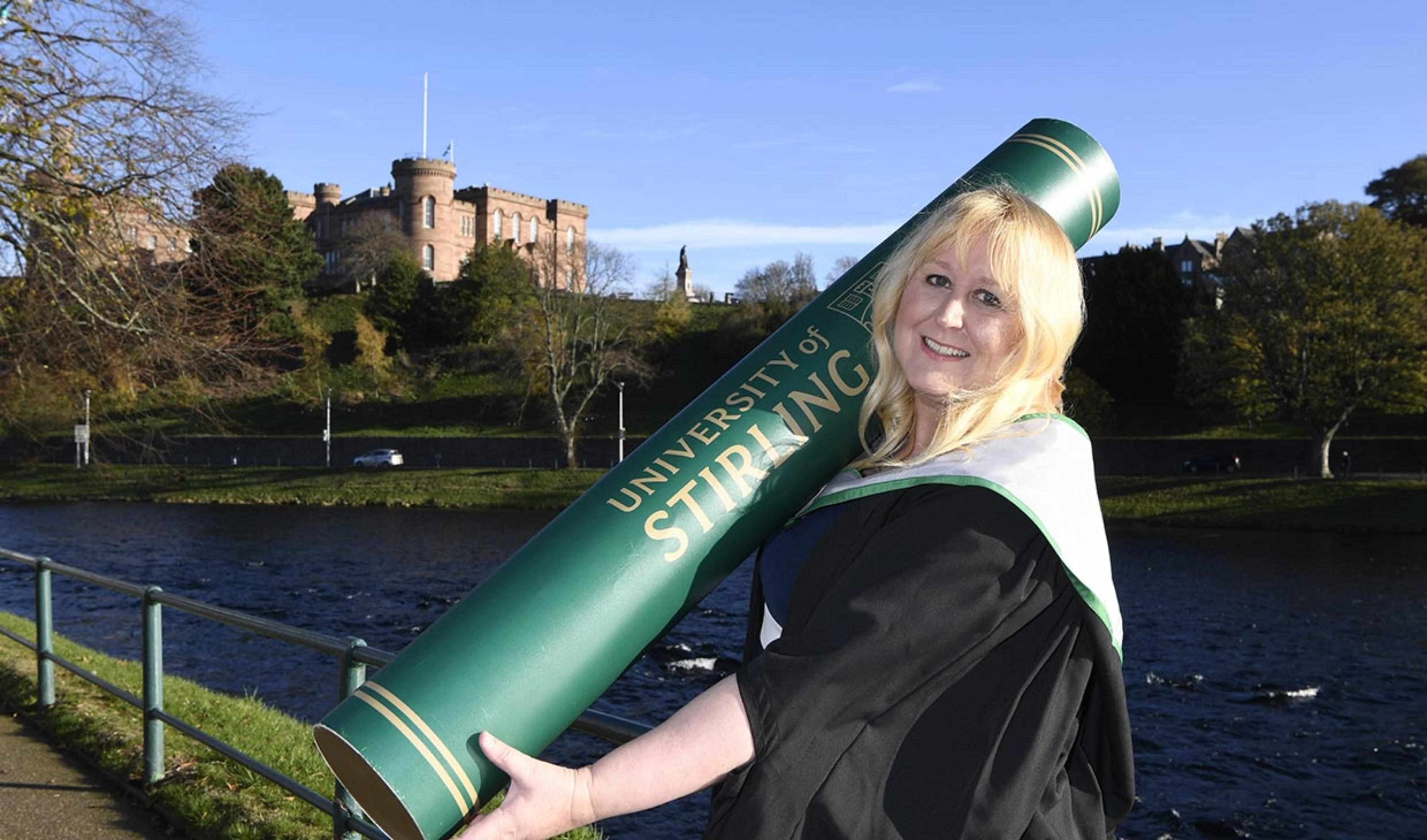 Image of Sara Wood-Kwasniewska with graduation scroll