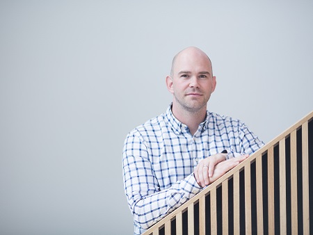 man in check shirt leaning on bannister