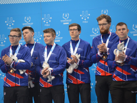 Ross Whyte with curling teammates on podium at World University Winter Games