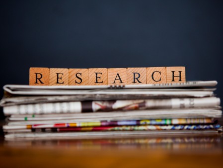 The word research spelled out in blocks sitting on top of a pile of books