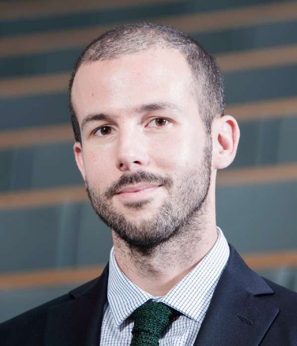 Dr Guido Noto La Diega. Head and shoulders photo of a man with very short dark hair, stubble and moustache wearing a shirt, tie and suit jacket looking directly to camera.