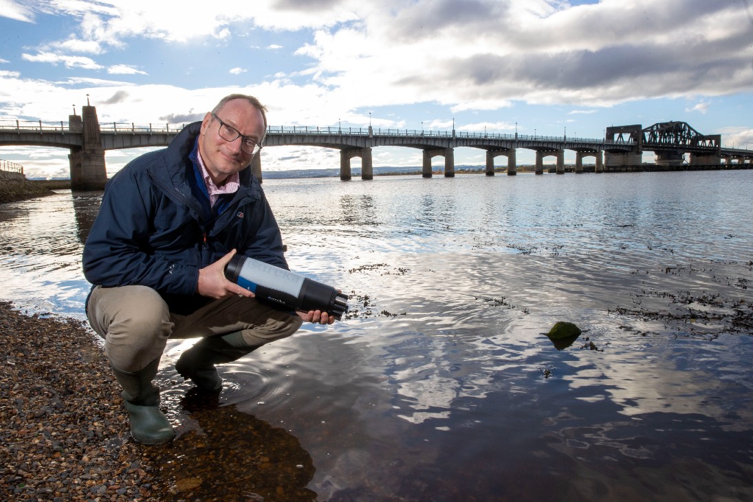 Prof Andrew Tyler holding a sensor by the Kincardine Bridge