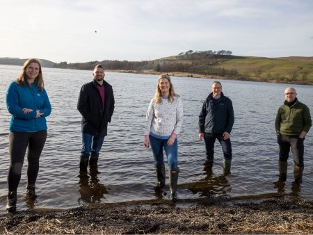 Hydro Nation Chair team standing by reservoir