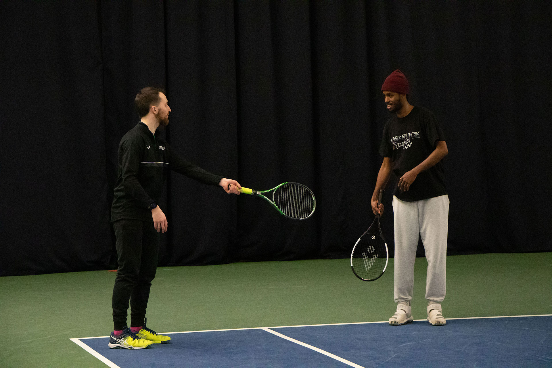 A student participates in a demonstration during a beginner's tennis lesson