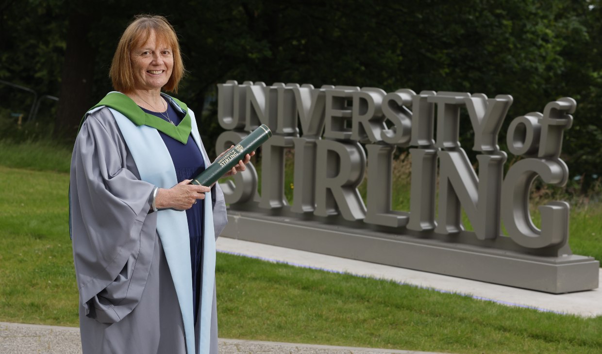 Judith Robertson poses next to University of Stirling sign.