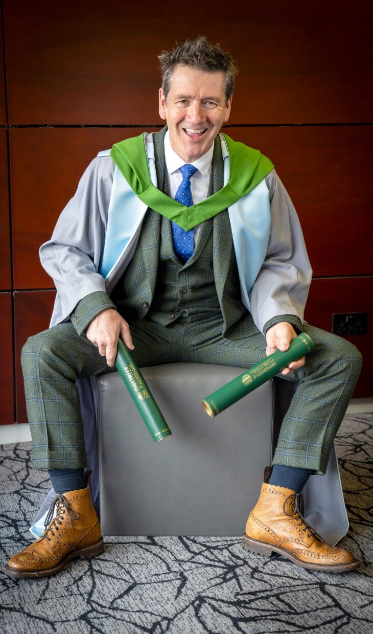 Dougie Vipond poses with his degree on the University of Stirling campus.