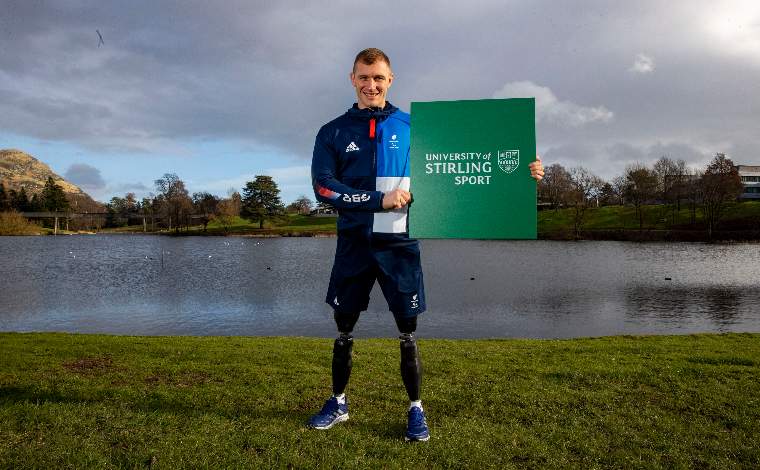 man with artificial legs holding sign