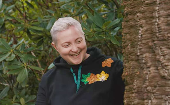 Forest bathing expert Cath smiling at a tree