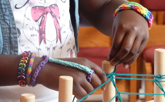 A pair of hands working at a loom