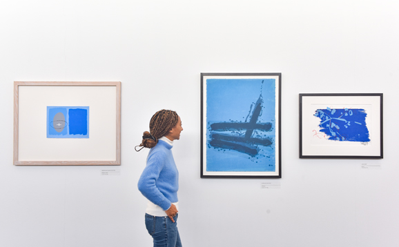 student looking at paintings in gallery