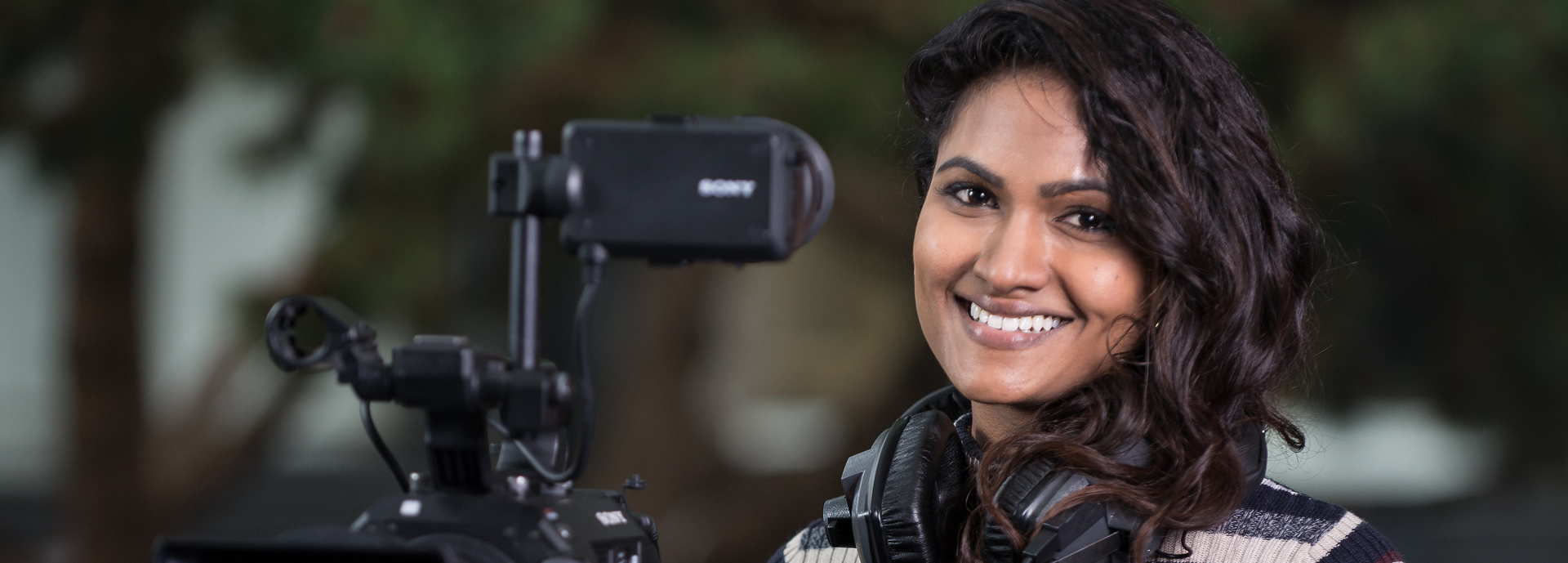 Postgraduate student with filming camera and headphones