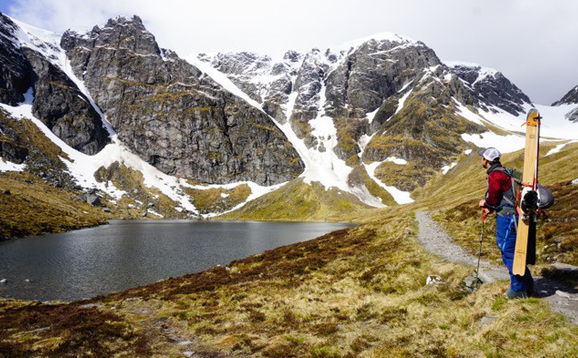 person with skis looking at mountains