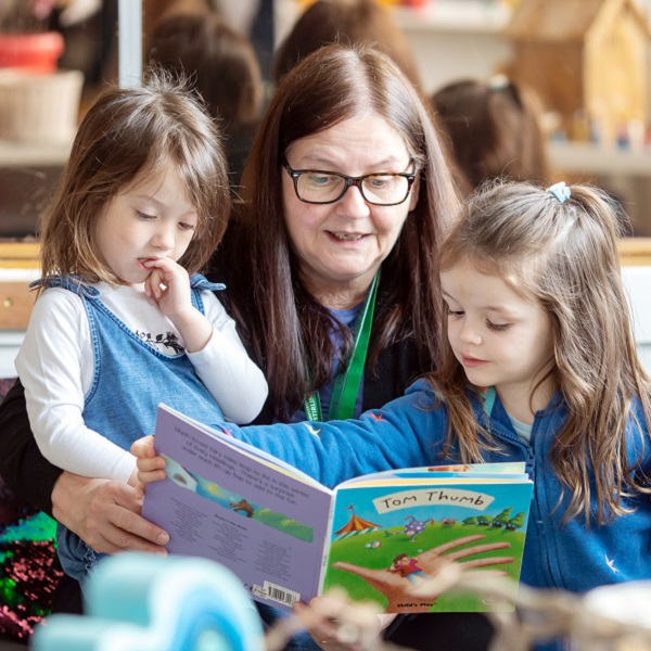 Member of staff reading to children in the kindergarten