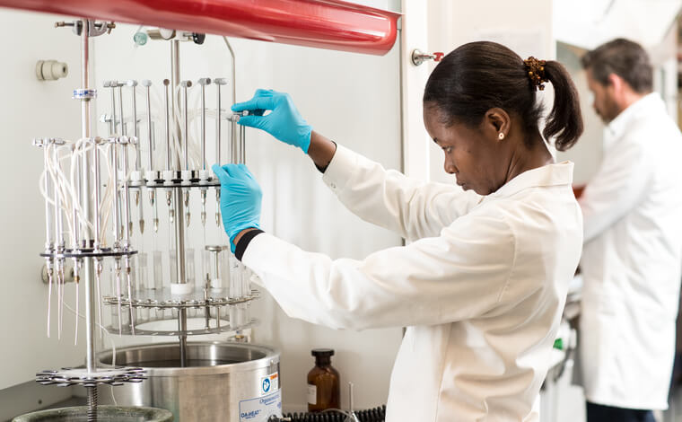 Woman in white lab coat using aquaculture equipment