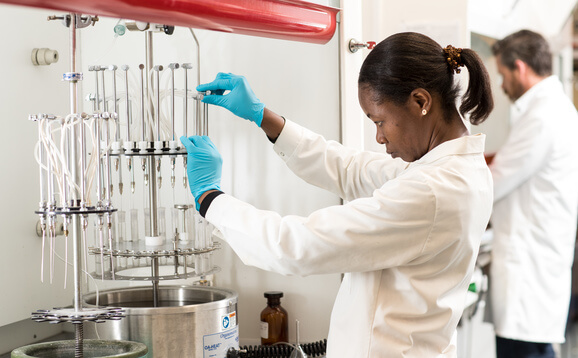 Woman in white lab coat using aquaculture equipment