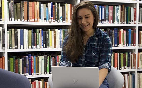 Student using a laptop in the library