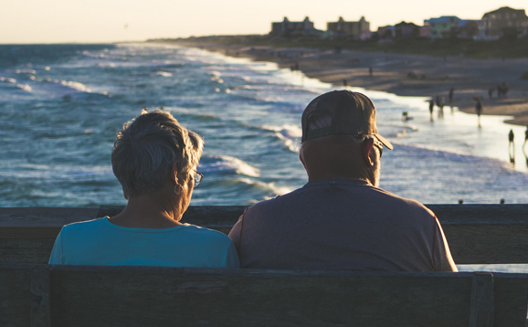 two people on bench at seaside