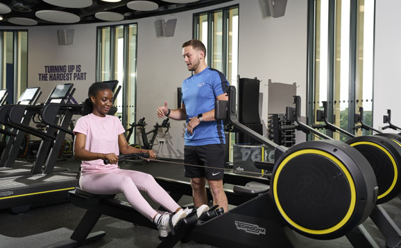 person using rowing machine in university gym