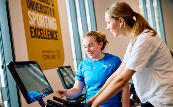 person using exercise bike with instructor